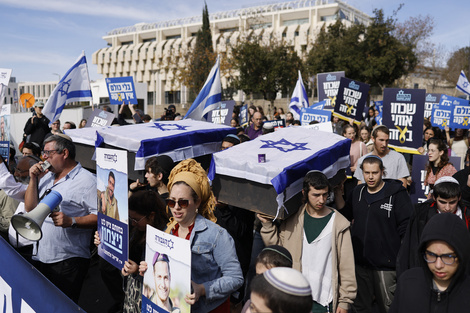 Manifestantes de extrema derecha portan ataúdes de cartón envueltos en la bandera de Israel