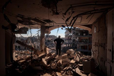 Un hombre observa la destrucción a su alrededor desde un edificio sin paredes en Rafah