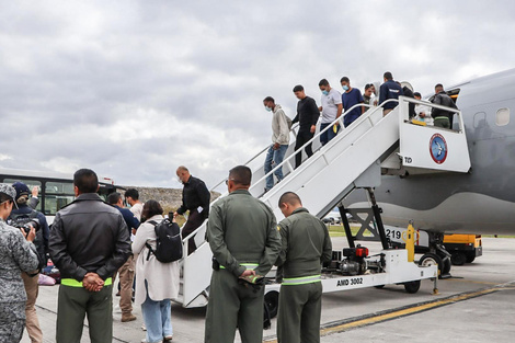 Un grupo de deportados desciende de un avión de la Fuerza Aeroespacial de Colombia