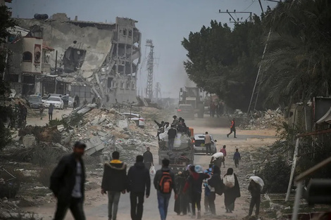 Palestinos desplazados caminan entre edificios destruidos en Rafah, Franja de Gaza.