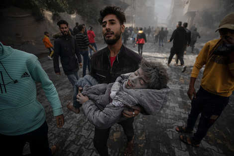 Imagen de archivo de un hombre que lleva a un niño herido tras ataques aéreos de Israel en la ciudad de Rafah. 