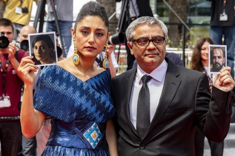 La actriz Golshifteh Farahani posó en Cannes junto a Rasoulof. Ambos sostienen las fotos de los actores de la película que aún permanecen en Irán. 