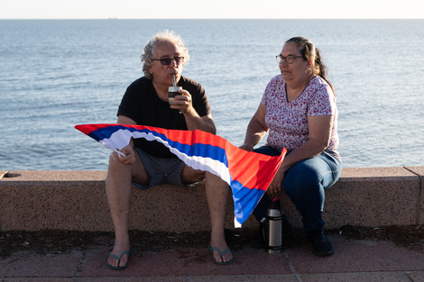 Simpatizantes del Frente Amplio toman mate en la rambla de Montevideo.