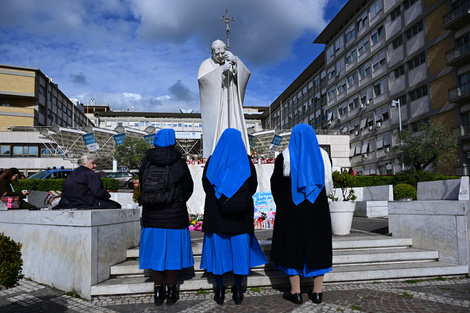 Tres monjas rezan por el Papa frente al hospital donde está internado.