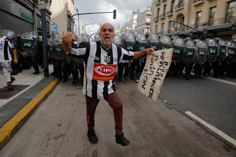 Manifestante con la camiseta de El Porvenir delante del cordón policial