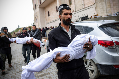 Hombres palestinos cargan los cuerpos de las víctimas en el norte de Gaza