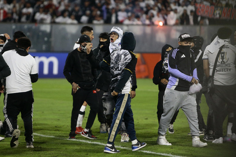 Aficionados de Colo Colo invaden el campo de juego después de la muerte de dos hinchas asfixiados por una avalancha tras una carga policial. EFE/ Osvaldo Villarroel