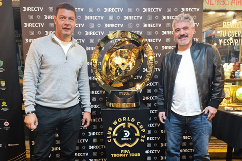 Sebastián Battaglia y Ariel Ortega, posan junto al trofeo del Mundial de Clubes