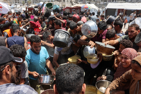 Palestinos se amontonan en un centro de distribución de comida cerca del puerto de la ciudad de Gaza