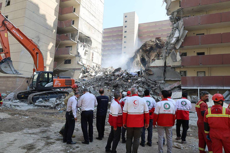 Miembros de la Media Luna Rojaobseran un edificio bombardeado en Teherán