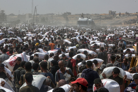 Refugiados palestinos cargan bolsas de comida en la Franja de Gaza. (Fuente: AFP)