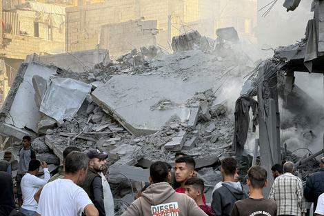 Varios hombres observan los escombros tras uno de los ataques lanzados este domingo por Israel en el centro de Gaza