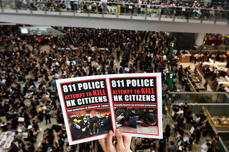 "La policía intenta matar a los ciudadanos de Hong Kong", dice el cartel. 