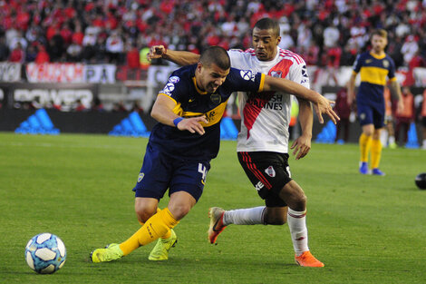 Weingandt y el uruguayo De la Cruz luchan en la mitad de la cancha.