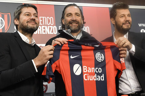 Pizzi, flanqueado por el presidente Lammens y el vice Tinelli.