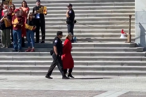 Fonda, llevada por un oficial, con la smanos atadas, durante la protesta en Washington. 