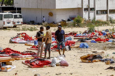 Migrantes caminan cerca del complejo penitenciario de Tajura después del bombardeo.