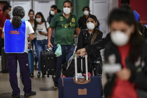 Pasajeros que llegan de países en riesgo, con barbijos en Ezeiza. (Fuente: AFP)