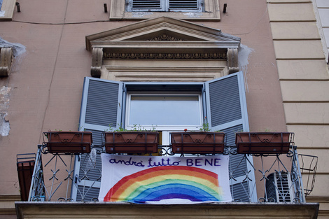 Una bandera colgada de un balcón en Milán con un mensje opimista y de superación.