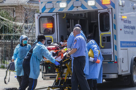 Enfermeros cargan a un enfermo de coronavirus en Queen, Nueva York. 