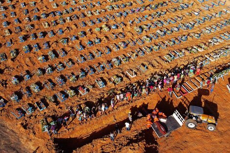 Un tractor descarga un ataud en un sector creado para muertos por el covid -19 de un cementerio en Manaos.  (Fuente: AFP)