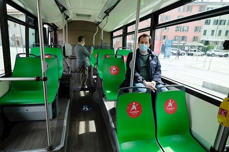 Un transporte pública casi vacío, en el que los asientos tienen carteles que marcan la distancia entre pasajeros. 