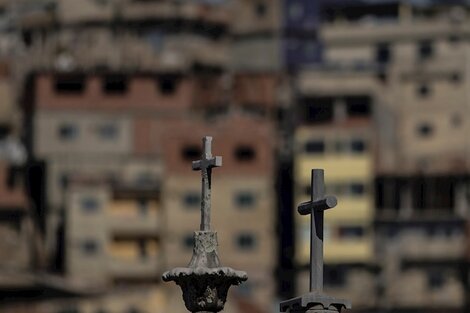 Las cruces de tumbas en un cementerio, con una favela carioca de fondo. 