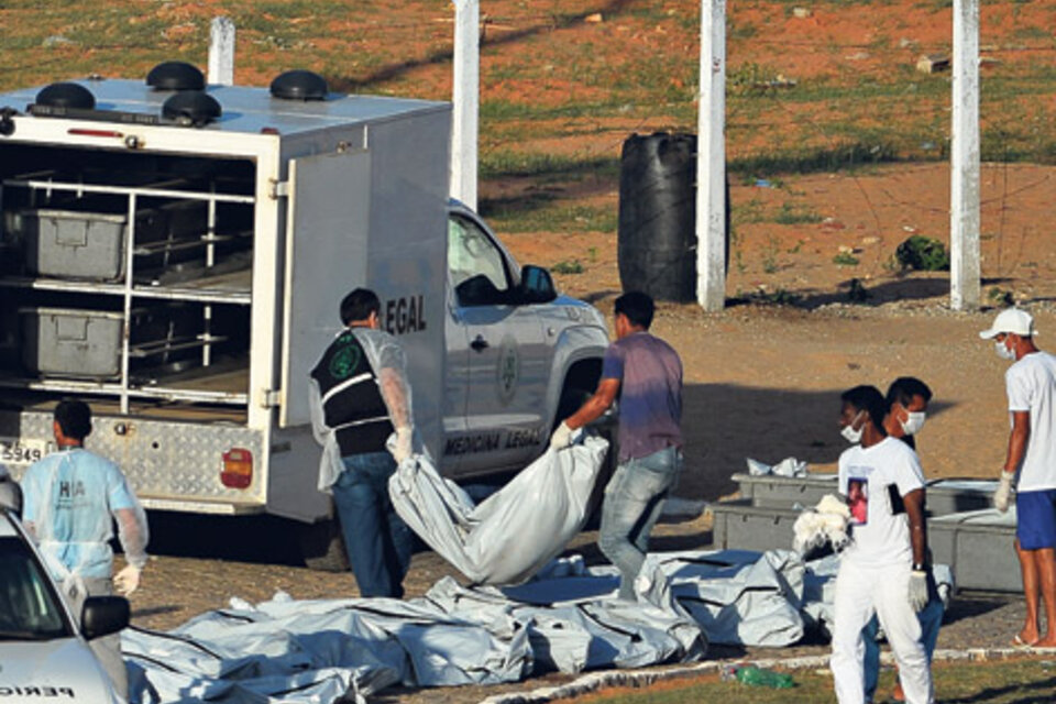 Personal sanitario retira los cuerpos de las víctimas de la pelea entre bandas en el penal de Alcacuz. (Fuente: AFP)