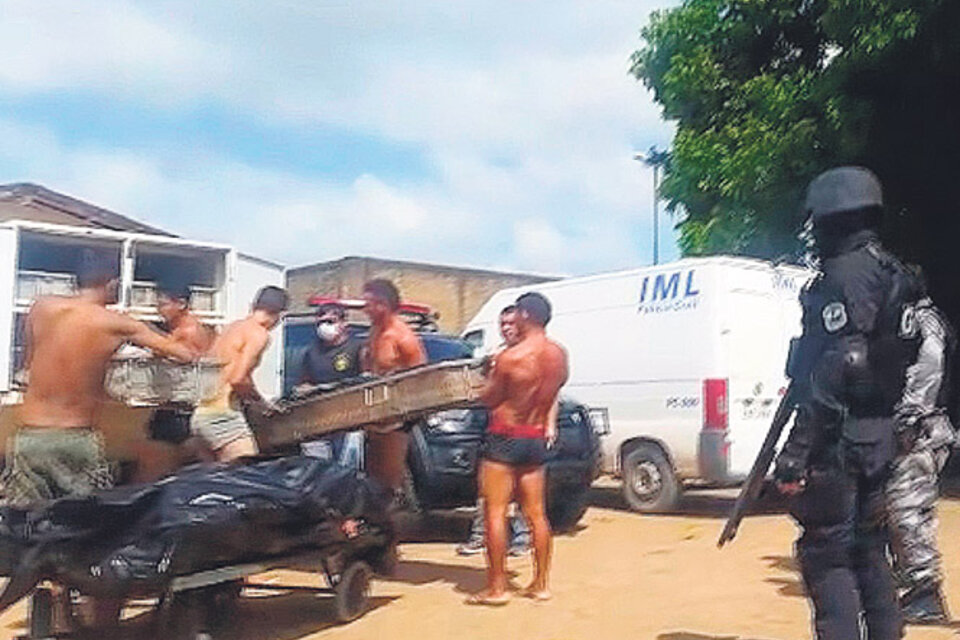 Reclusos cargan cadáveres en vehículos después de la masacre de Roraima. (Fuente: AFP)