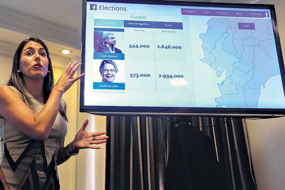 La coordinadora de una ONG electoral muestra una imagen con los dos candidatos. (Fuente: EFE)