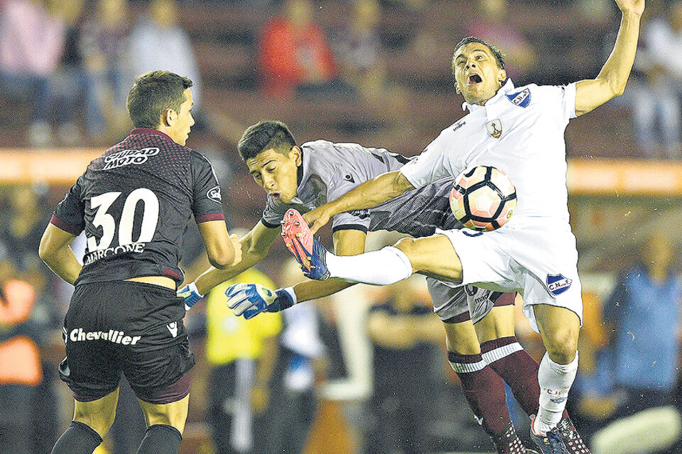 Andrada intenta frenar a Fernández, Marcone mira la pelota.  (Fuente: AFP)