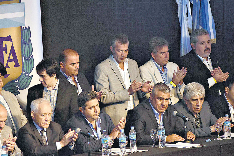 Claudio Tapia (entre Angelici y Moyano), junto a sus compañeros de la única lista que se presentó a la elección en el marco de la Asamblea Extraordinaria. (Fuente: DyN)