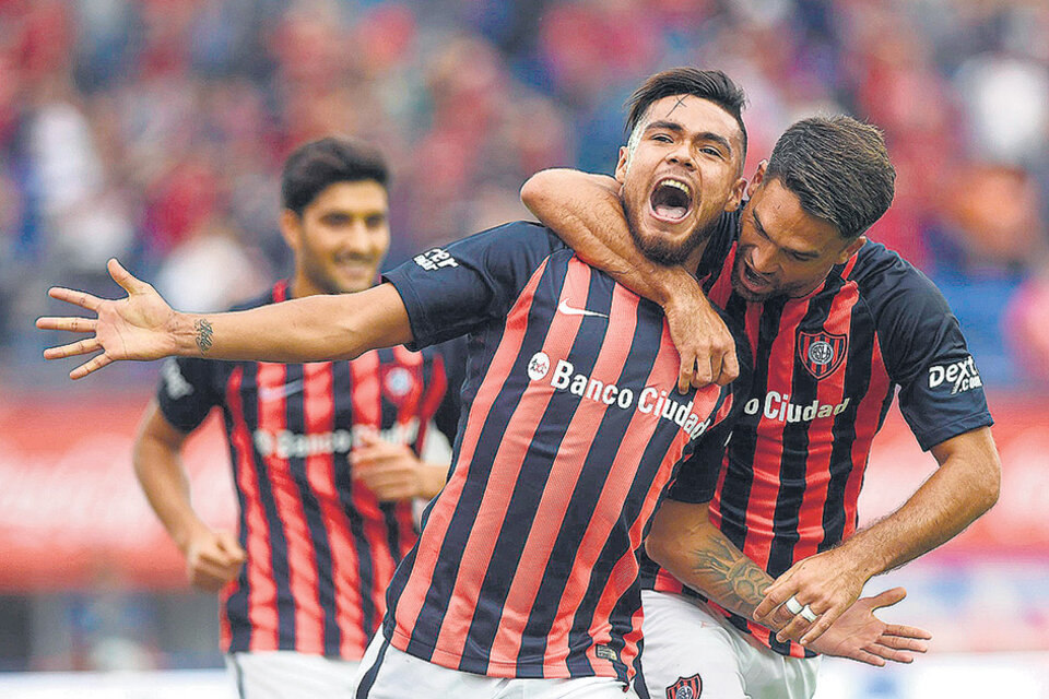 El abrazo de Caruzzo para el chileno Díaz, con su boca llena de gol. Blandi corre para sumarse al festejo. (Fuente: Télam)