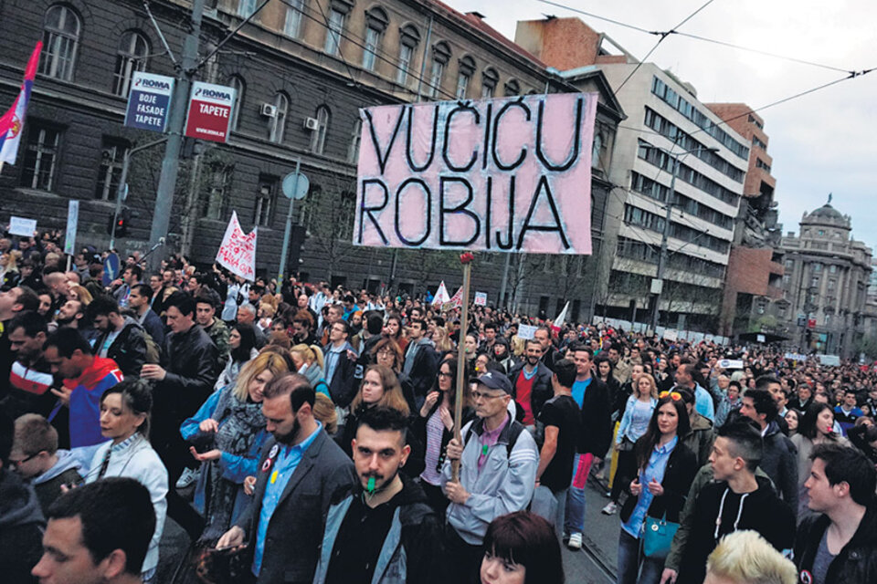 Manifestantes en Belgrado, entre ellos un hombre que sostiene una pancarta pidiendo “Cárcel para Vucic”.
