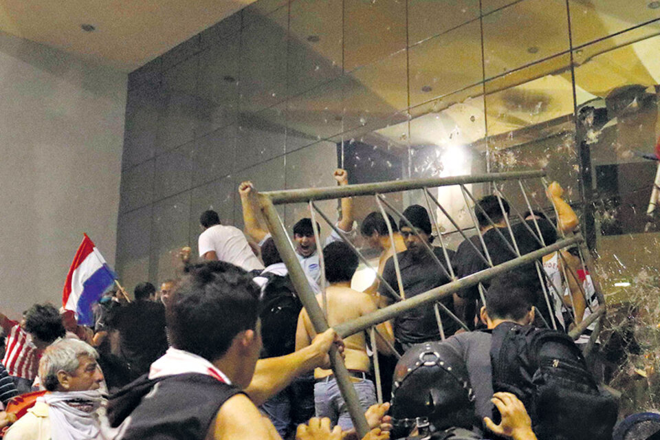 Unos centenares de manifestantes rompieron vallas y prendieron fuego al Congreso Nacional en Asunción.