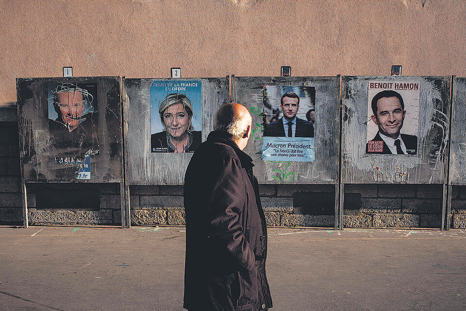 Un hombre pasa frente a unos afiches de campaña de los principales candidatos en Lyon horas antes del voto. (Fuente: AFP)