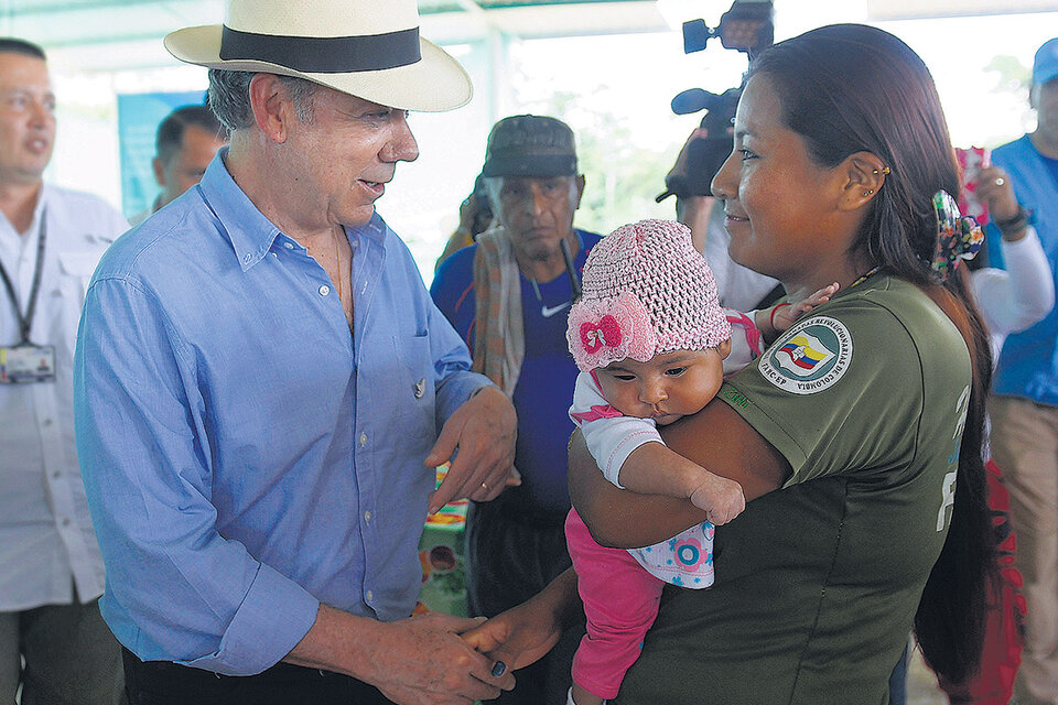 El presidente Santos habla con una guerrillera durante su visita a una zona veredal. (Fuente: EFE)