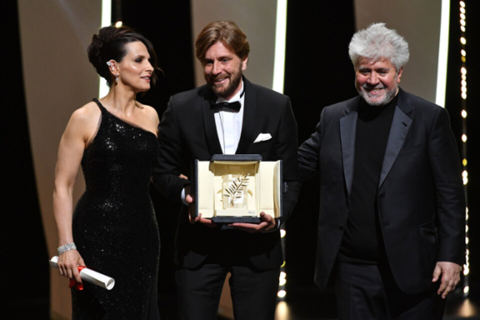 Juliette Binoche y Pedro Almodóvar entregan la Palma de Oro al director sueco Ruben Östlund. (Fuente: AFP)