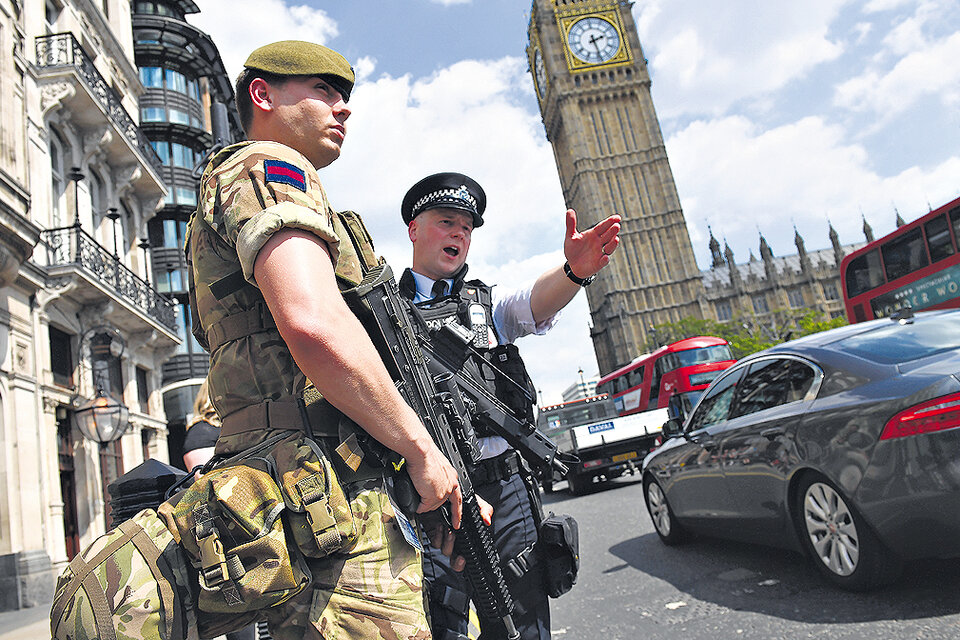 Un soldado y un policía vigilan cerca del Parlamento británico tras el atentado en Manchester.