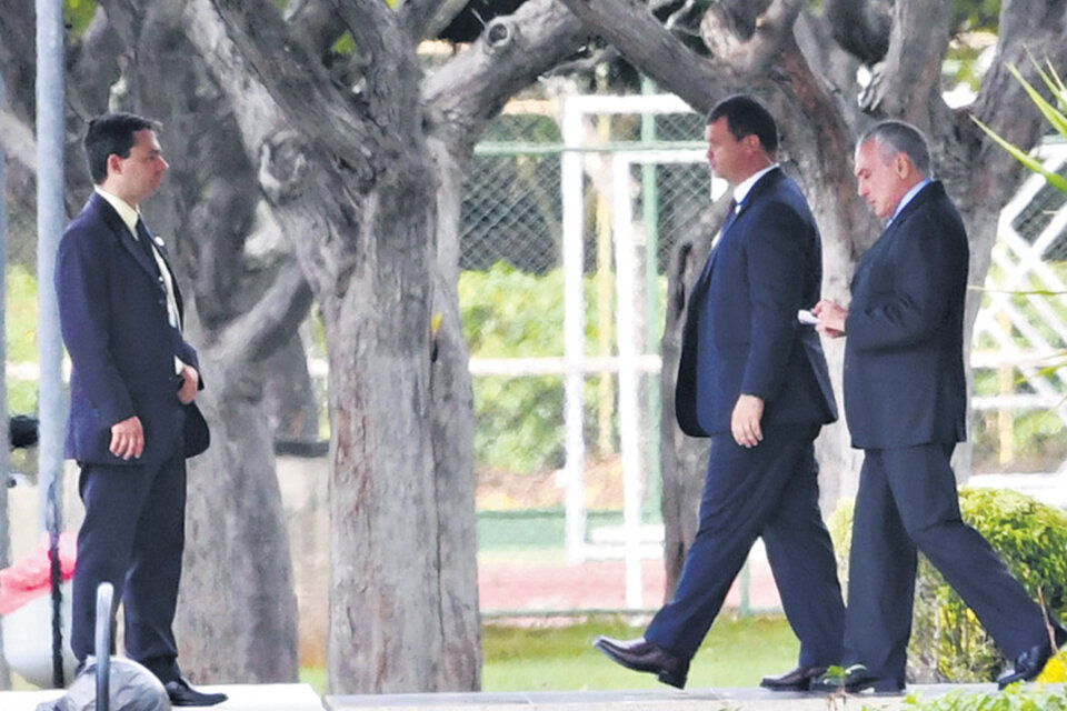 Temer (der.) sale de la residencia presidencial rumbo al palacio de gobierno en Brasilia.