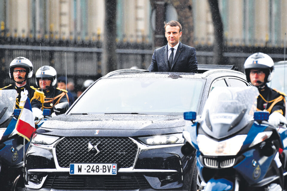 Bajo una fina lluvia, Macron recorrió la famosa avenida parisiense Champs Elysées en un vehículo descubierto. (Fuente: AFP)