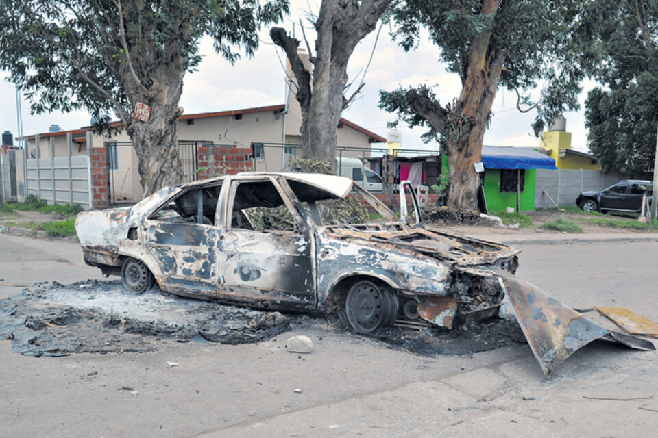 Uno de los autos quemados durante el enfrentamiento. A unos metros encontraron un cadáver quemado. (Fuente: Télam)