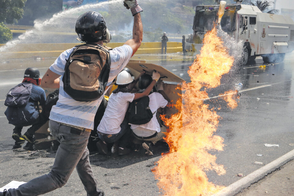 Manifestantes se enfrentan a la Guardia Nacional Bolivariana ayer en Caracas. (Fuente: EFE)