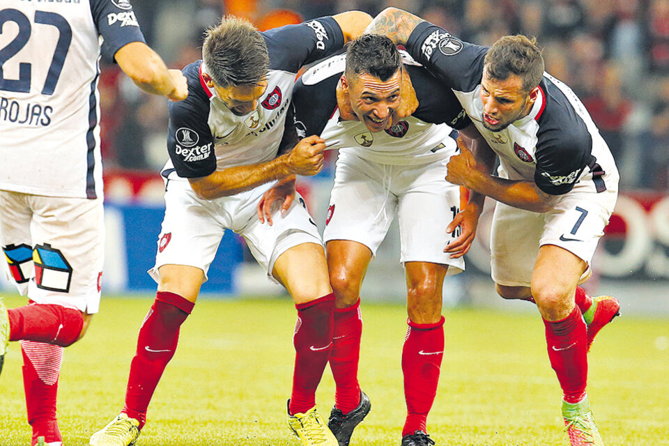 Botta festeja su gol, el tercero de San Lorenzo, abrazado por Mussis y Caruzzo. (Fuente: EFE)