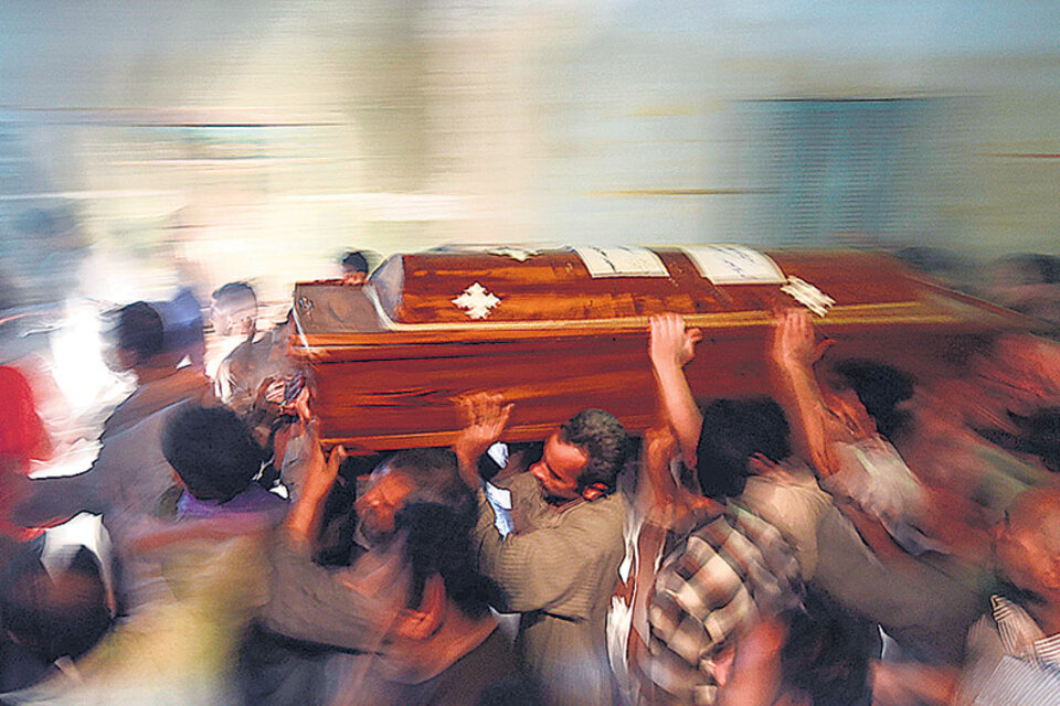 Familiares de una de las víctimas cargan el cajón. (Fuente: AFP)