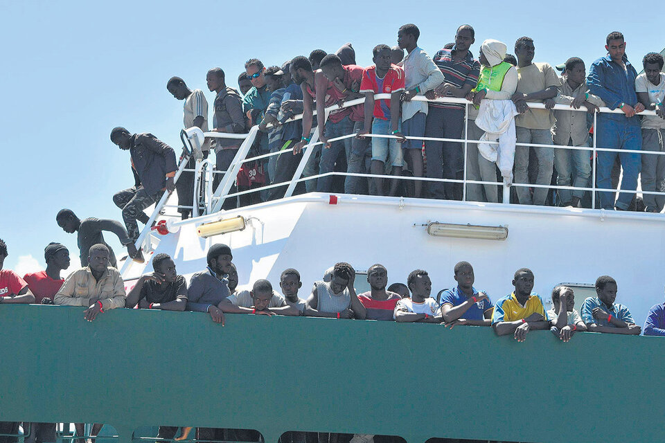 Migrantes que esperan desembarcar al llegar al puerto de Salerno. (Fuente: EFE)