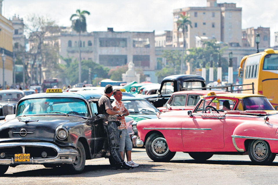 Dos taxistas esperan la llegada de turistas en el centro de La Habana. (Fuente: EFE)