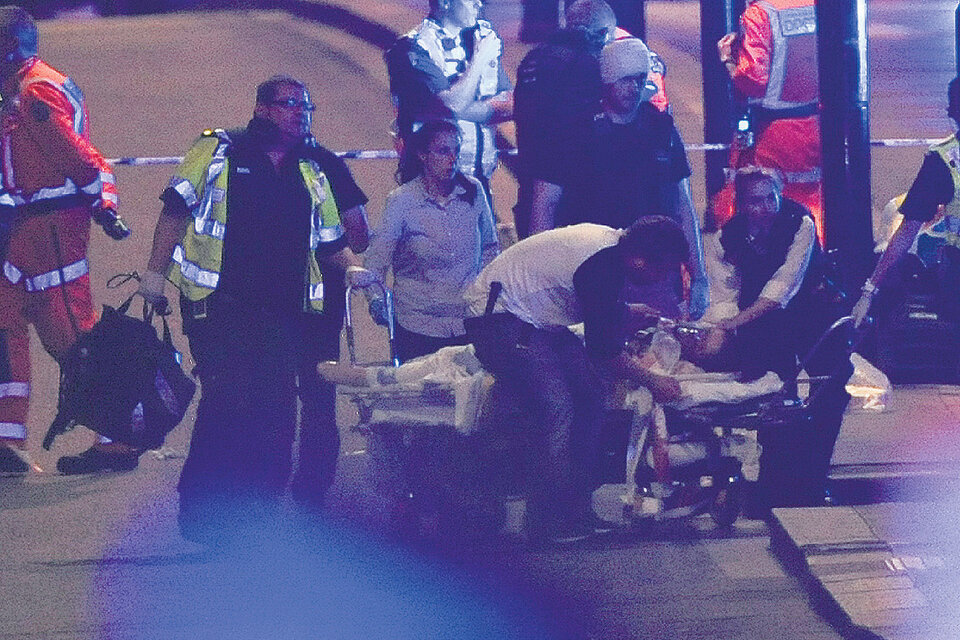 Policías y enfermeros atienden a una de las víctimas del atentado en el puente de Londres ayer a la noche. (Fuente: AFP)