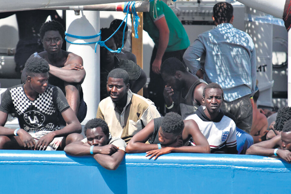 Varios de los 650 migrantes que fueron rescatados esperan para desembarcar en Catania, sur de Italia.