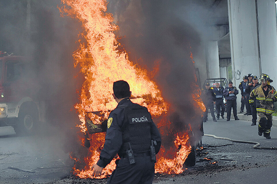 Policías y bomberos mexicanos trabajan en la escena del tiroteo entre marinos y una banda narco en el D.F. (Fuente: AFP)